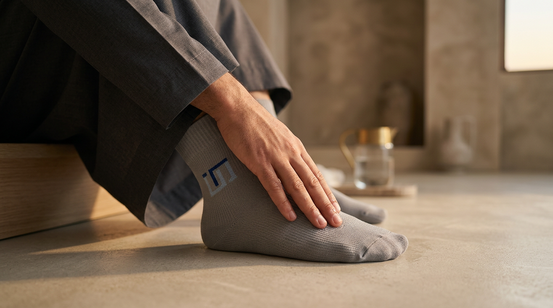 Masah über Wudhu Socken: Hand wischt über die Oberseite einer grauen Wudhu Socke